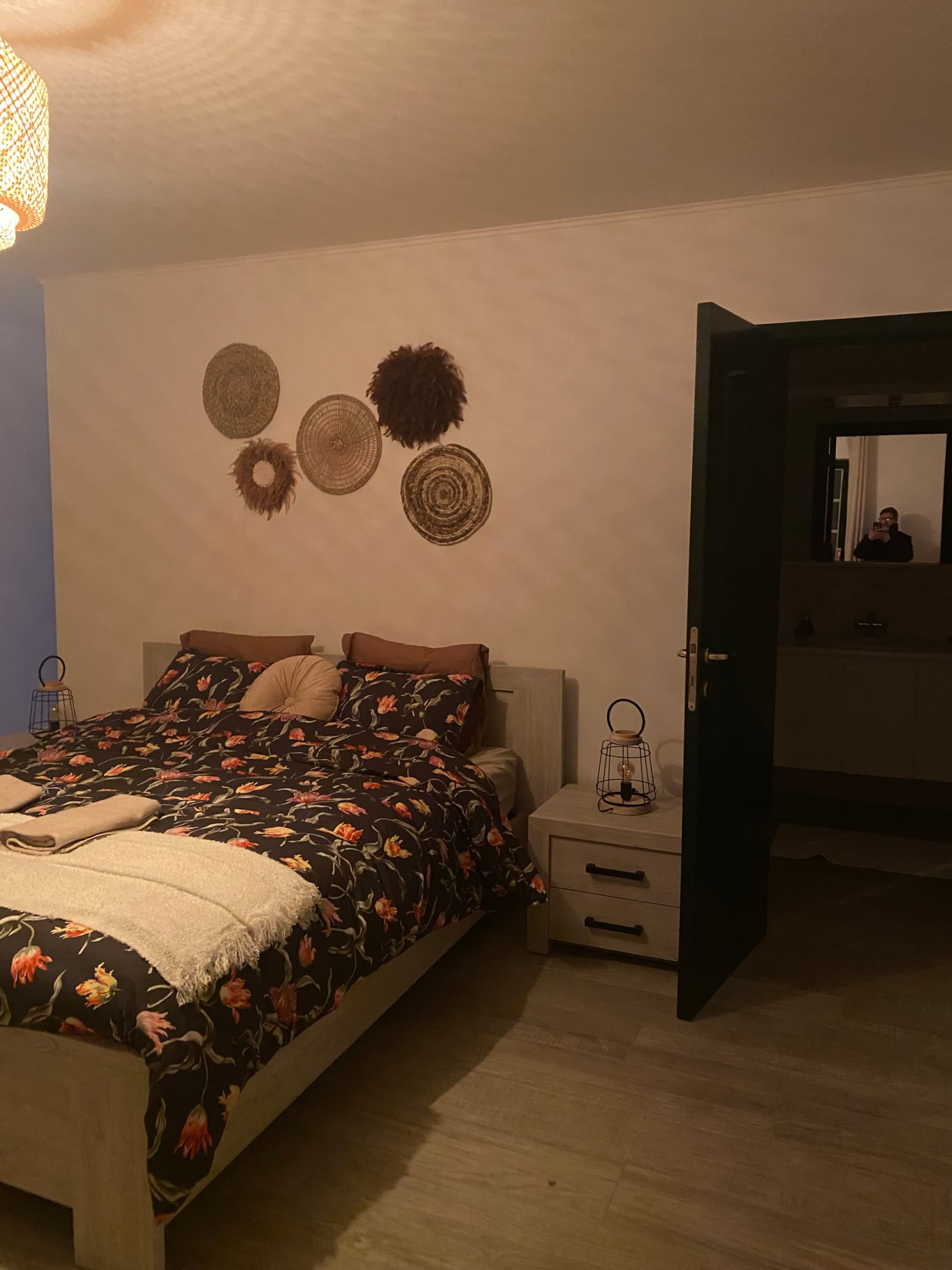 Chambre 2 de La Porte de l'Ardenne : lit double, tables de nuit et paniers décoratifs au mur