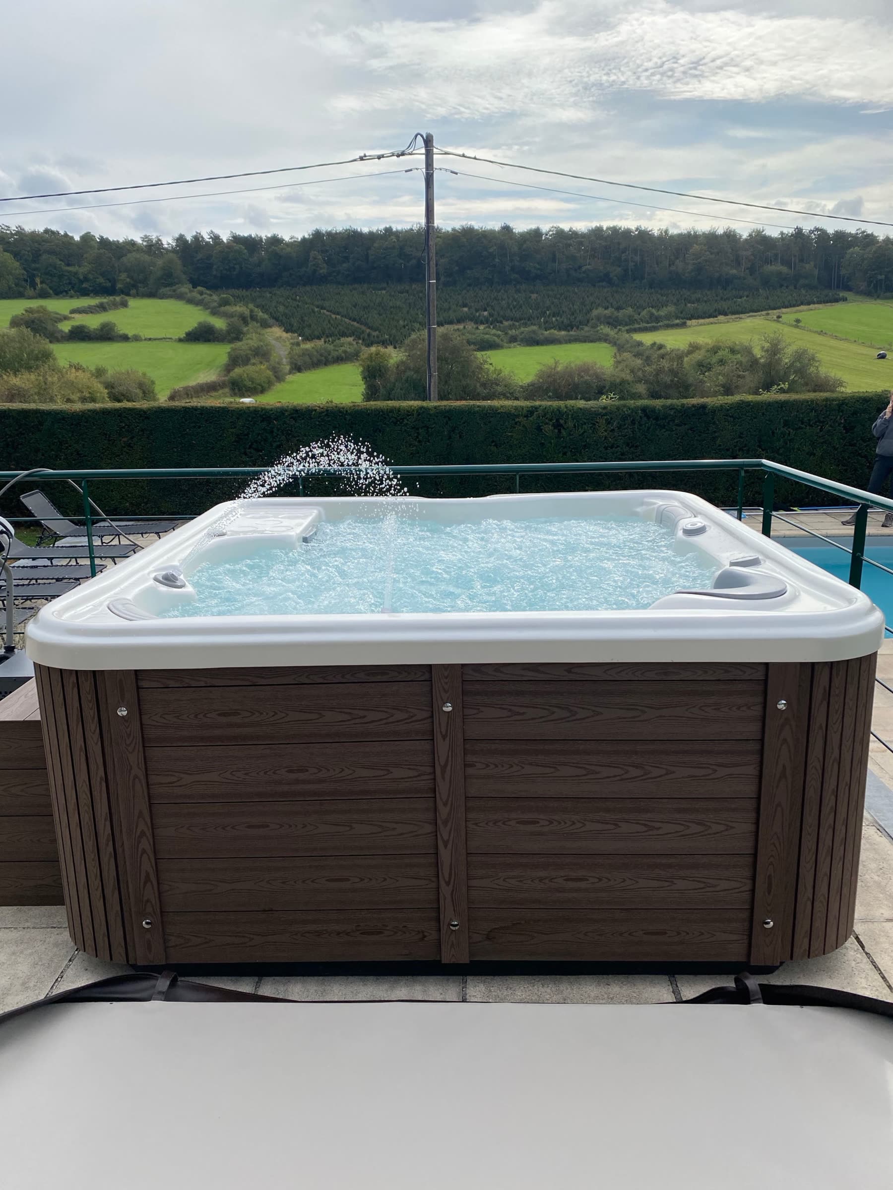 Le jacuzzi privé de La Porte de l'Ardenne, en terrasse face à la campagne ardennaise et à la piscine